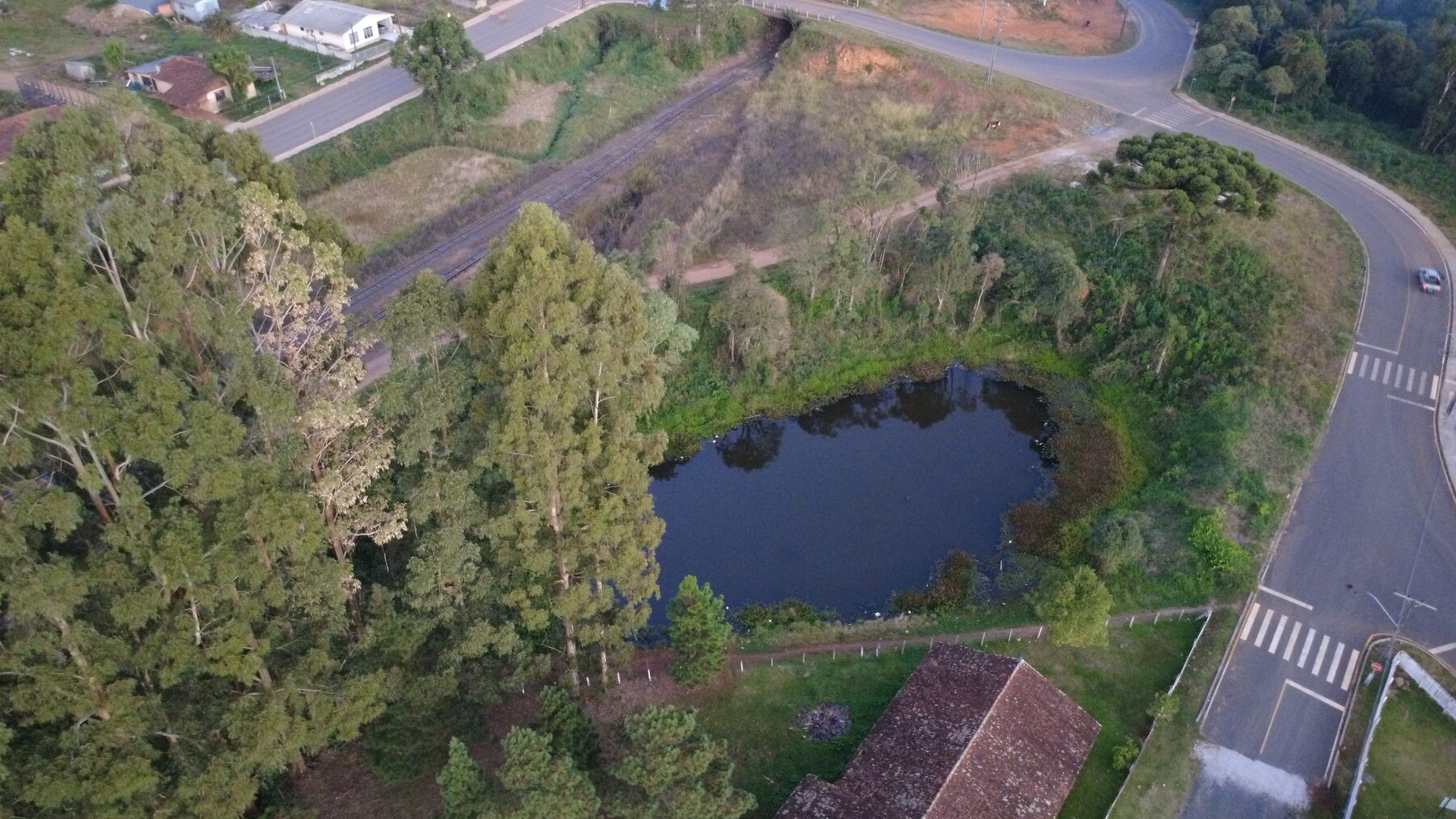 Espelho d'água cercado por eucalipto próximo a área urbana